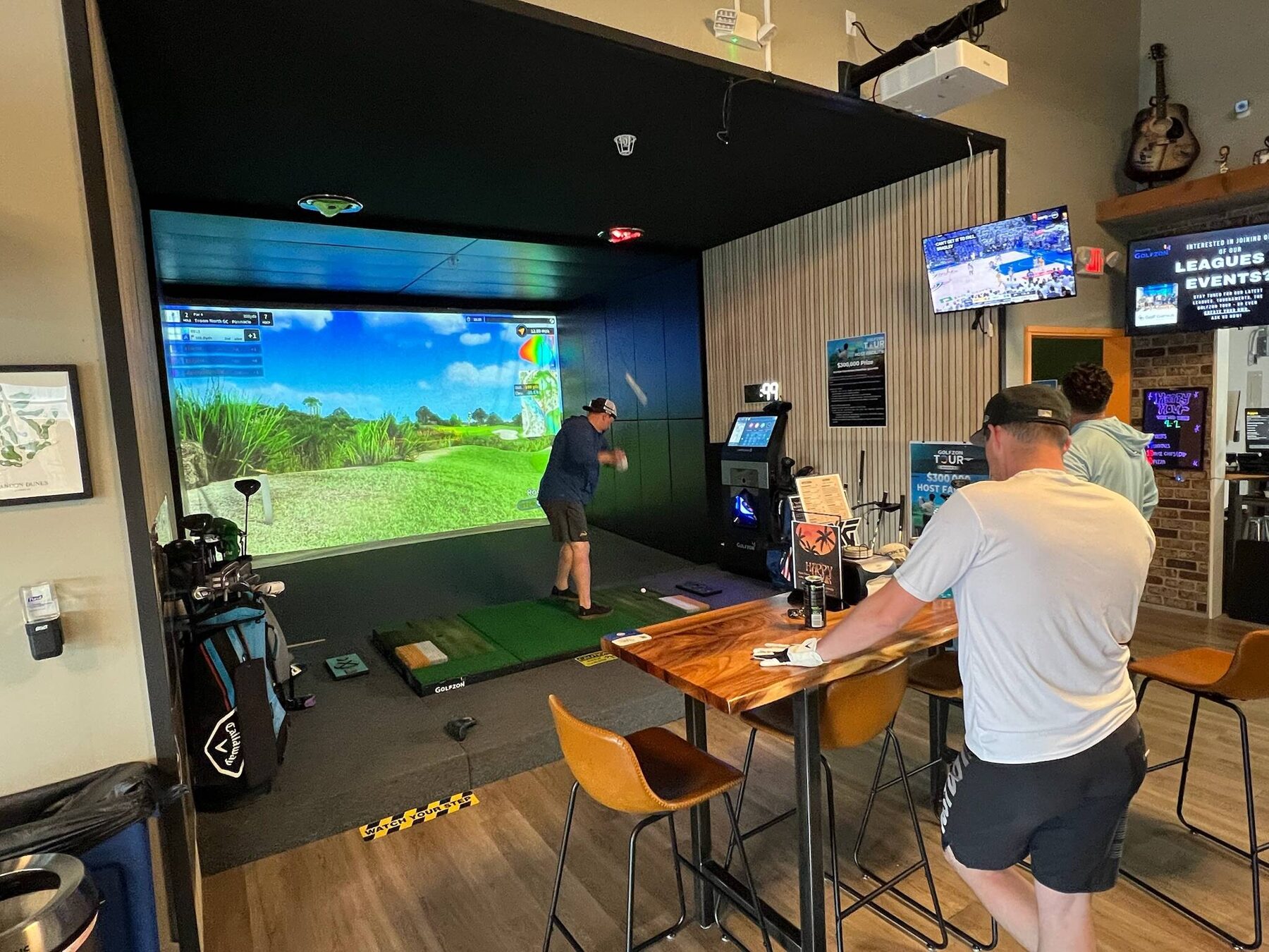 Pin Seeker Indoor Golf & Sports Grill venue with simulator bays and sports screens